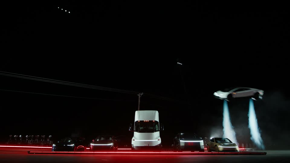 The Roadster rises beside the line-up on two downward gas jets, from flat ground.