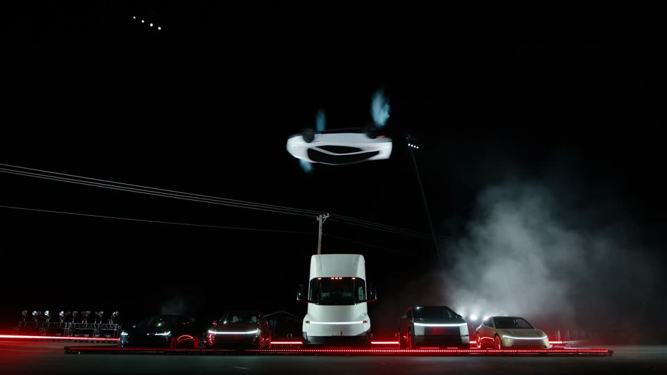 Upside down above the Semi, jets pointing up. Lines cross the sky by a pole behind the Semi.